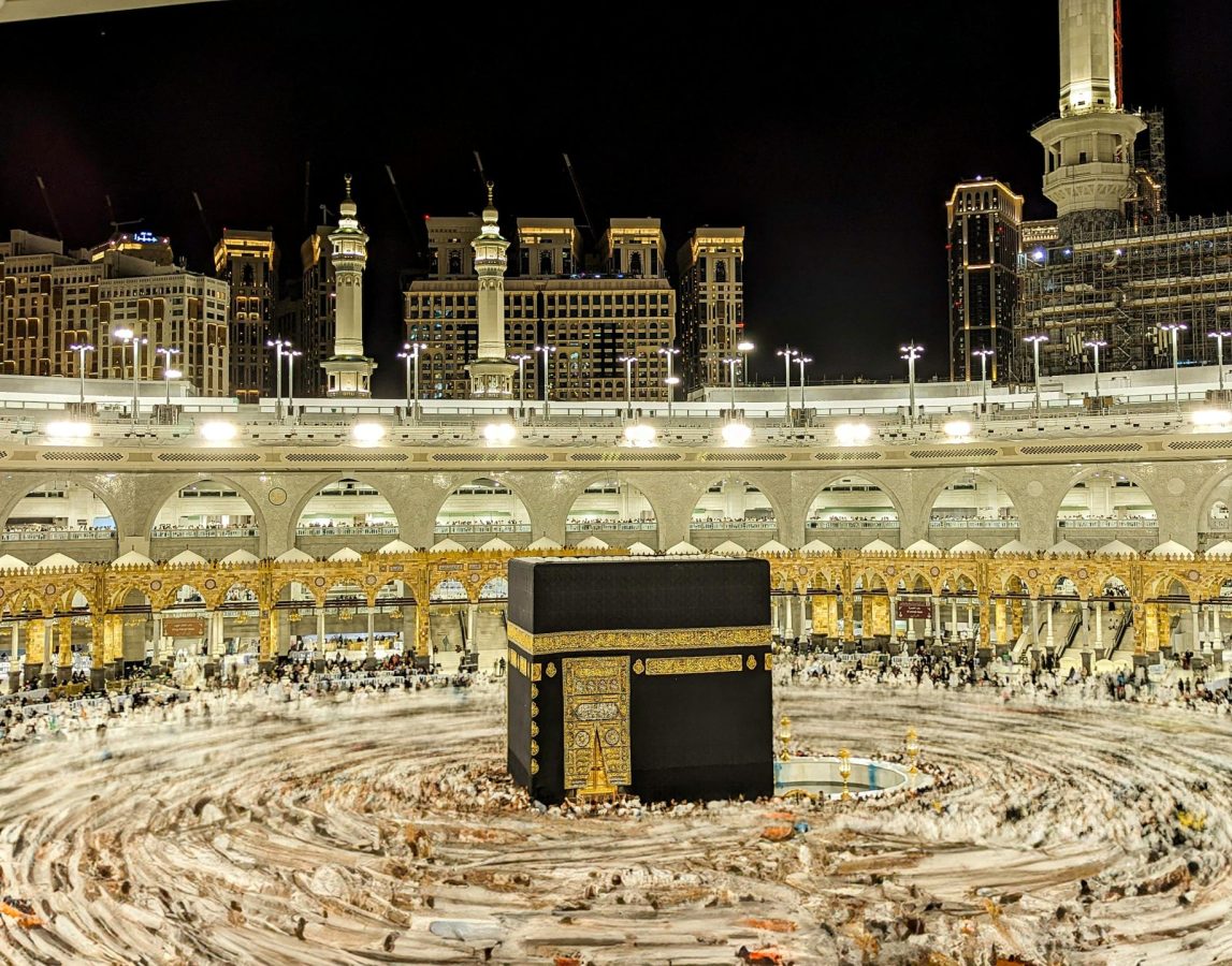 Vibrant night view of the Kaaba in Mecca, capturing Islamic architecture and worshippers.